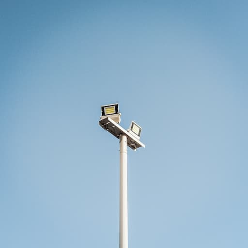 快晴の空を背景に、白い双頭の電灯が立っている。二つの光源のうち一つは向かって右を、もう一つはこちらを向いている。