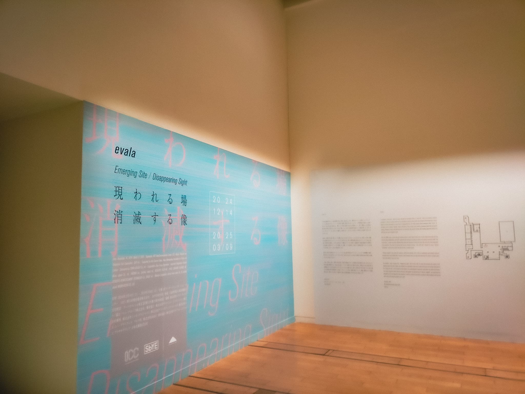 展示の入口横の壁に展示のタイトルとビジュアルが描かれている